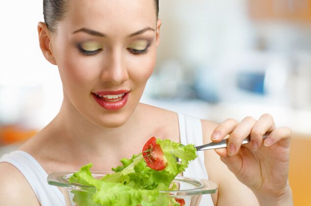 Dans la poursuite de l'objectif de perdre du poids en une semaine, la fille mange des aliments partiellement sains